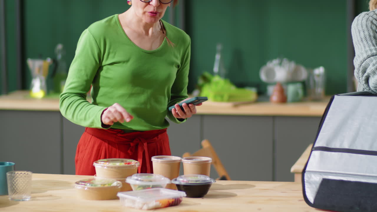 mensajero femenino con máscara y guantes descargando comida saludable para el cliente