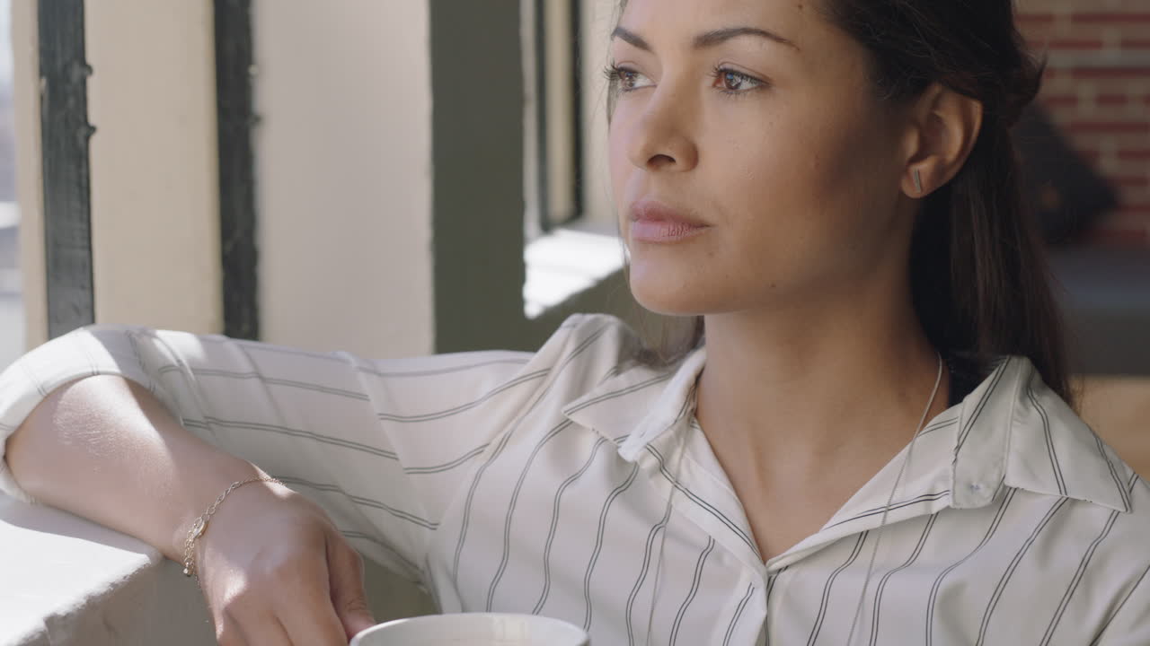 hermosa mujer hispana bebiendo café en casa disfrutando de una mañana relajada mirando por la ventana pensando contemplativamente