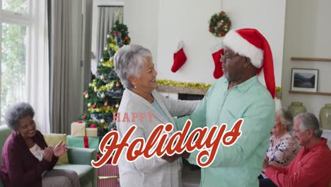 Animación-Del-Texto-De-Felices-Fiestas-En-Rojo-Sobre-Una-Feliz-Y-Diversa-Pareja-De-Ancianos-Bailando-En-Una-Fiesta-De-Navidad