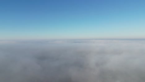 drone footage going up through a layer of fog