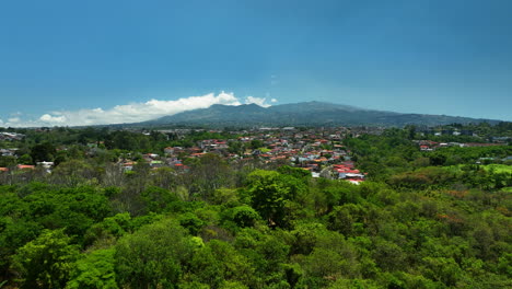 drone rising over a blooming cherry tree, revealing the san jose city, costa rica