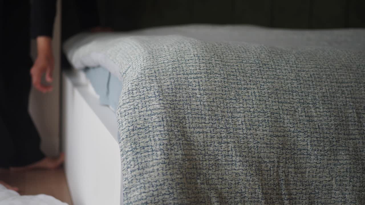 편안한 침실에서 침대를 만드는 사람