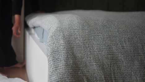 persona haciendo la cama en un dormitorio acogedor