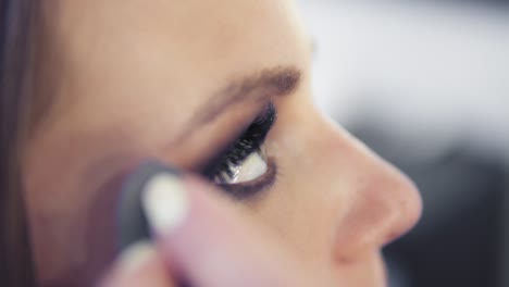 Vista-De-Cerca-Del-Maquillador-Quitando-La-Sombra-De-Ojos-Con-Un-Pincel-De-Maquillaje.-Maquillaje-Profesional.-Tiro-En-Cámara-Lenta