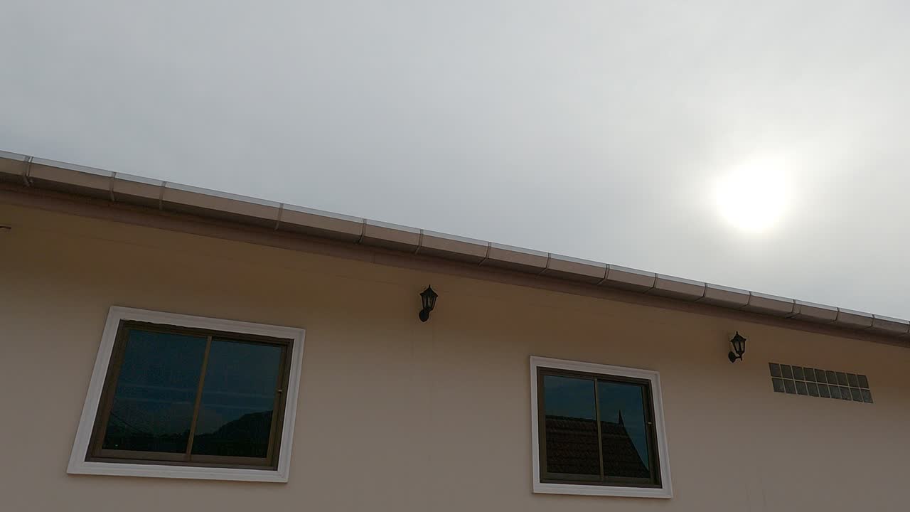 el sol brillante de la mañana el rayo de luz brillando al amanecer el cielo azul sobre el techo de la casa