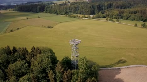 a drone orbits the gehrenbergturm lookout tower near lake constance