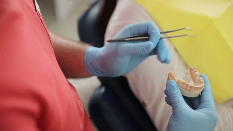 using tweezers, the dentist cautiously explores the patient’s mouth, examining their teeth with precision.