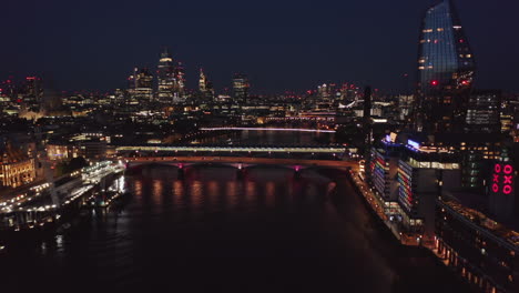 Los-Delanteros-Nocturnos-Vuelan-Sobre-El-Río-Támesis.-Vista-Panorámica-De-La-Ciudad-Iluminada-Por-Luces-De-Colores.-Hotel-De-Contenedores-Marítimos-Y-Un-Rascacielos-Blackfriars-En-La-Orilla-Sur.-Londres,-Reino-Unido