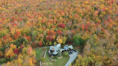 aerial view of countryside house in colorful autumn forest, scenic landscape of new england usa, drone shot