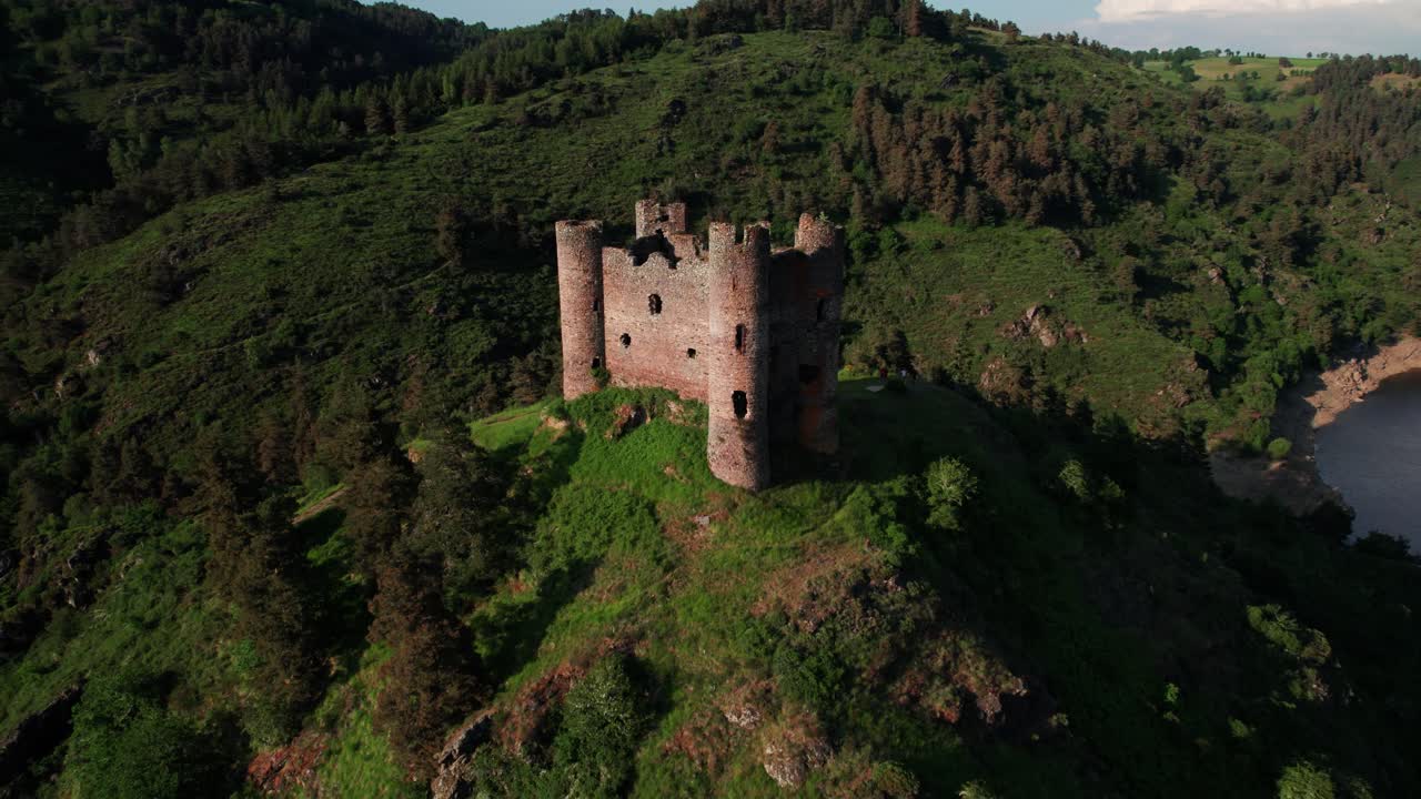 aerial shot revealing Alleuze Castle and landscapce at sunset on a sunny day, Cantal department, Auvergne Rhone Alpes region, France