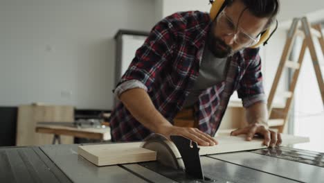 Zoom-out-video-of-carpenter-cutting-wood-on-a-circular-saw