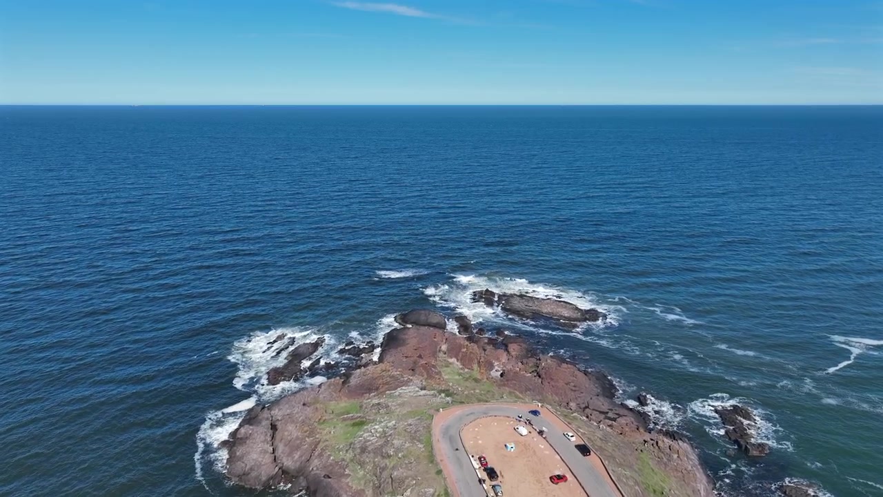 Penisola costiera rocciosa di Punta Ballena con area di parcheggio e ripresa aerea dell'oceano con avanzamento sull'Atlantico in Uruguay.