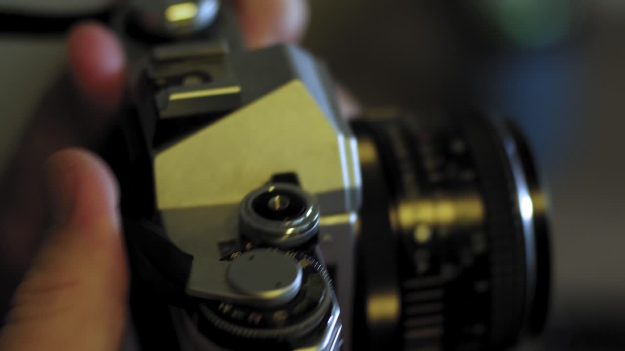 Man takes a photo and advances to the next image with a vintage 35mm film camera