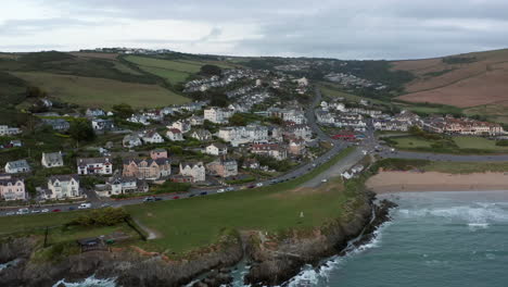 aerial fly away from a coastal town at sunset