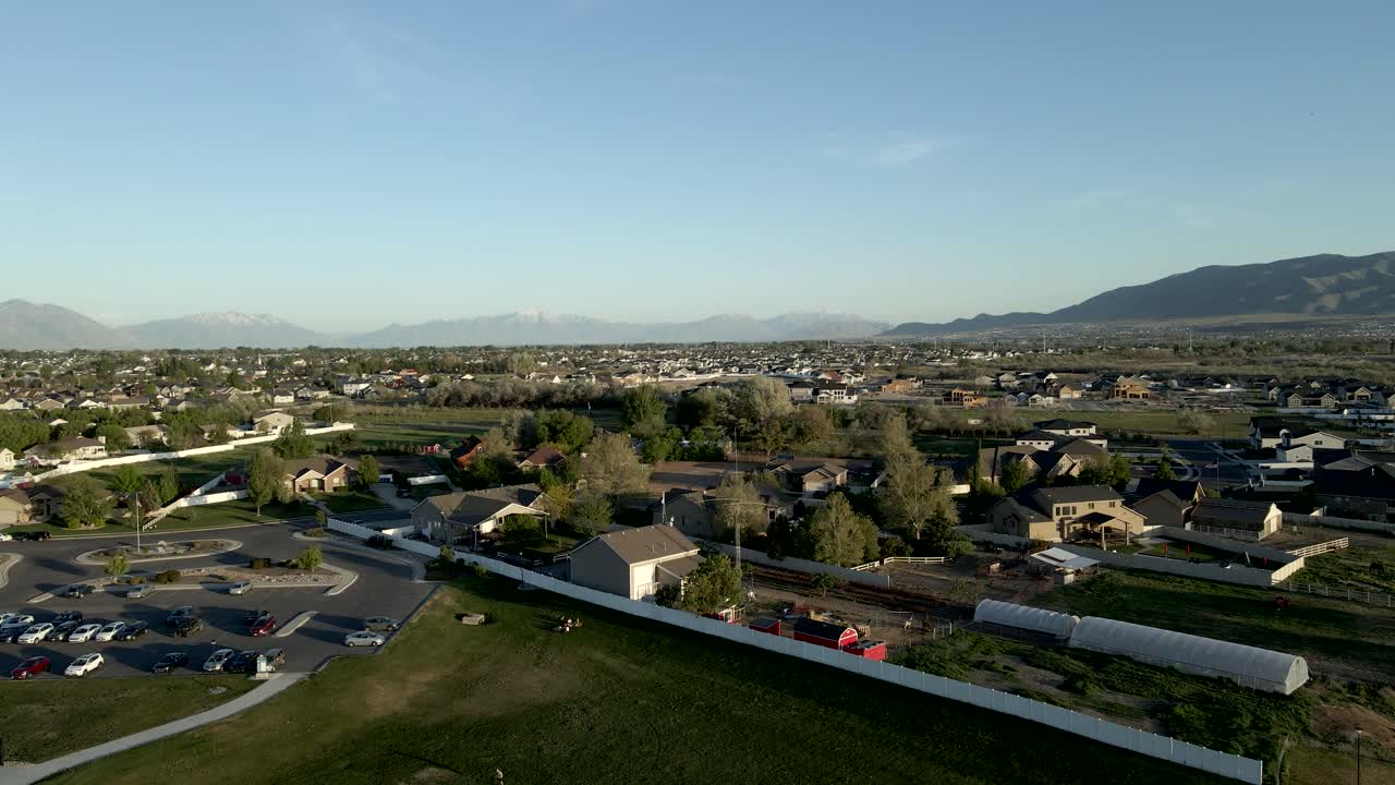 Una comunità suburbana vicino a un parco con montagne in lontananza - sorvolo aereo
