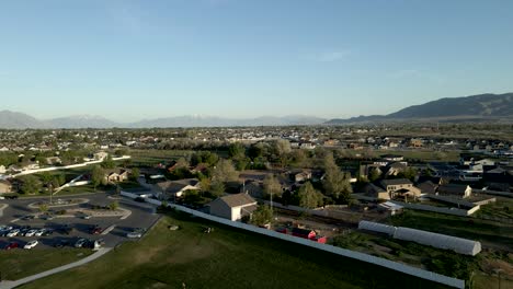 a suburban community next to a park with mountains in the distance - aerial flyover