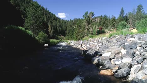 un pescador con mosca lanza a lo largo de las orillas de un río de alta montaña