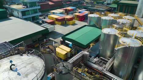 drone shot of large-scaled modern industrial area with palm oil tanks and cargo containers , malaysia