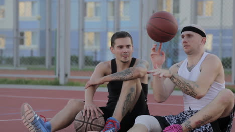 two men playing basketball on a street court