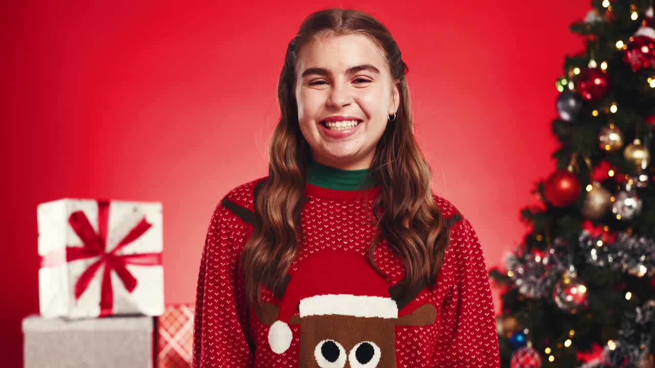 Woman in Christmas sweater with Christmas tree and gifts