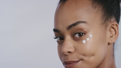 portrait beautiful young african american woman applying skin cream moisturizer on face enjoying exfoliation massaging luxury anti aging lotion perfect feminine beauty on white background skincare concept