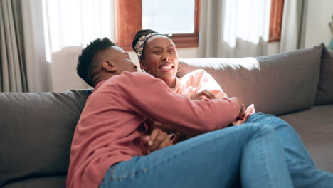 Man,-woman-and-tickle-on-sofa-in-home-with-laugh