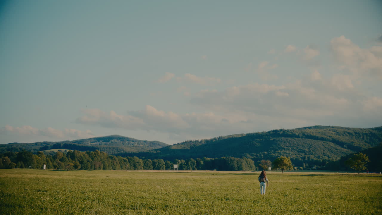 무관심 한 여자 가 초원 에 있는 잔디 에 달리고 있다