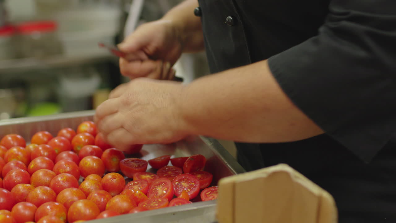 레스토랑 주방 에서 은 토마토 를 잘라내는 여자 의 손