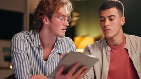 two men discussing something on a tablet