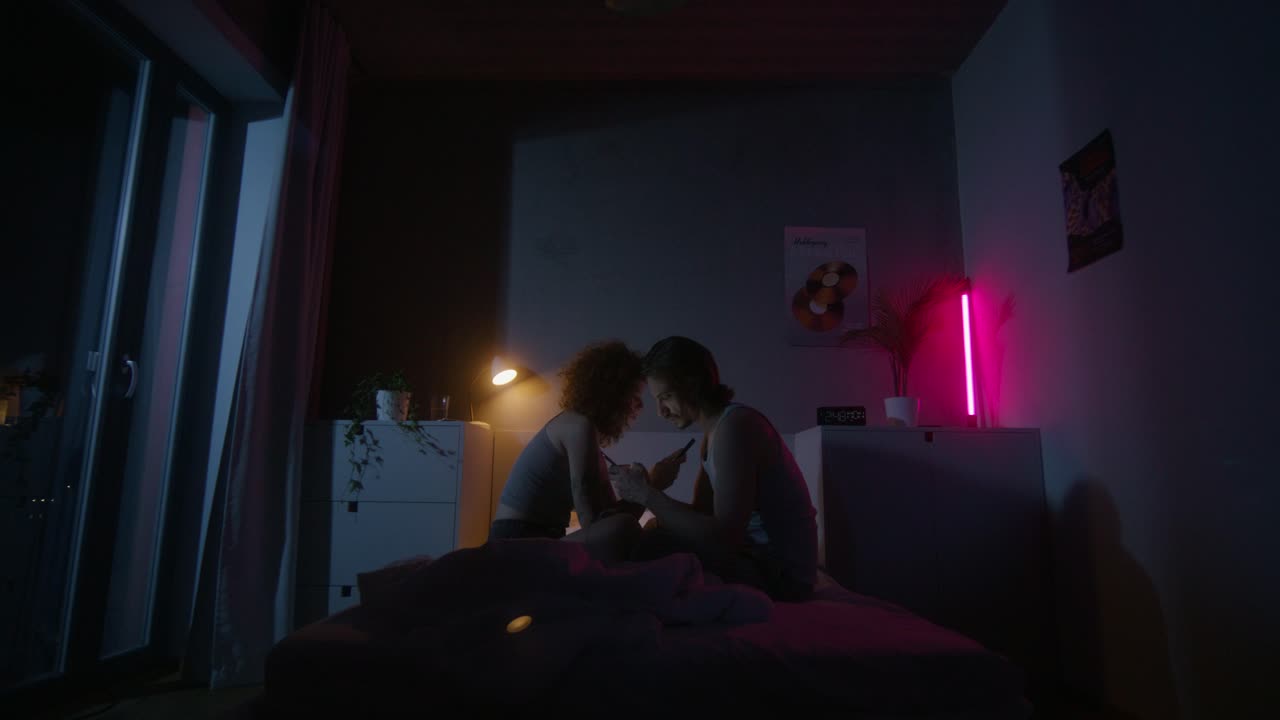 밤 에 침대 에 앉아 있는 부부