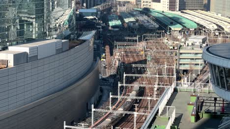 a train station with multiple tracks and modern architecture, sunny day, aerial view