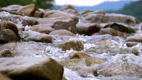 clear stream running through stone boulders abundant river flowing in slow motion