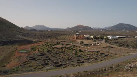 un coche conduciendo a través de edificios poblados con un jardín en la isla de lanzarote, españa