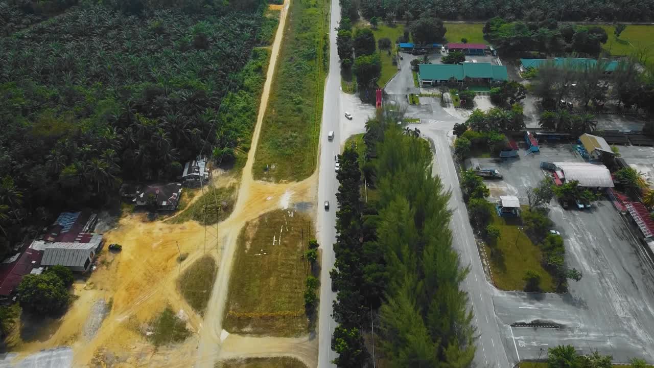 야자유 공장 폐수 거주지의 영화적 드론 영상은 인도네시아에 있는 야자나무 삼림 벌채로 둘러싸인 건물, 주택, 주요 도로 및 인프라로 구성되어 있습니다.