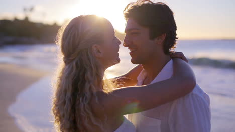 Pareja-En-La-Playa-Durante-El-Atardecer-Besándose