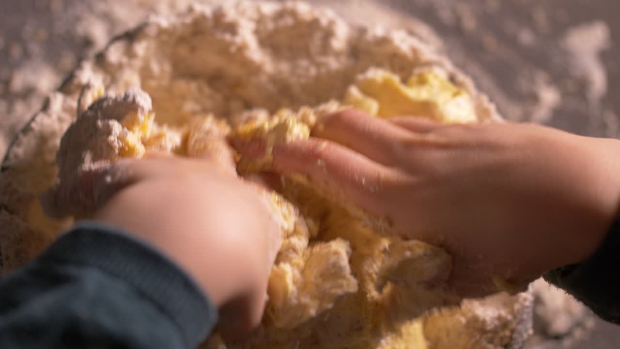 Close up, little child's hands mixing butter and flour mix in bowl