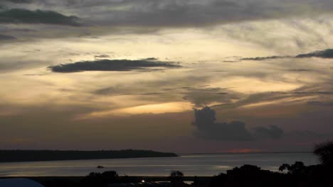 el río negro o río negro que desemboca en el río amazonas - lapso de tiempo de puesta de sol de gran angular con cruce de botes al atardecer
