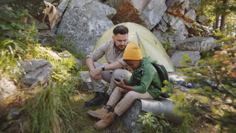 boy using smartphone while camping with dad