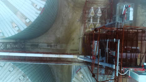 Huge and massive constructions at crops processing plant. Top view of the granary complex exterior. Grey foggy weather backdrop.