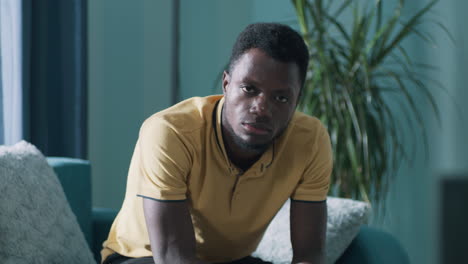 portrait of a serious young african american man looking directly at the camera indoors