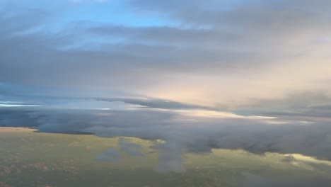 Flying-across-a-a-sky-with-some-fluffy-colorful-clouds-in-a-real-time-flight-shot-from-a-jet-cabin-flying-near-Barcelona,-Spain,-at-7000m-high