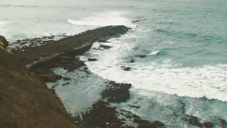 Ocean-waves-crash-against-the-shore-on-an-October-morning-at-a-cliff-in-Peniche,-Portugal