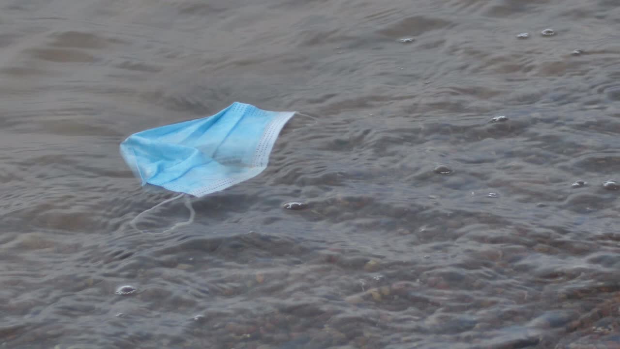 해변에 있는 의료용 일회용 파란색 보호 마스크, covid-19 코로나바이러스 바이러스의 낭비