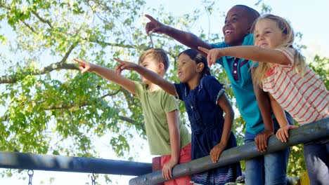 niños apuntando hacia un lejano en el patio de recreo 4k