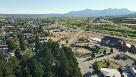 Aerial-dolly-in-of-Trevelin-main-square-and-houses-with-mountains-in-background,-Patagonia-Argentina