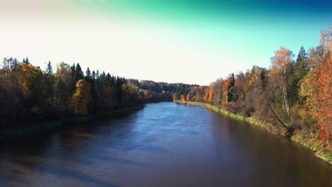 autumn river landscape with colorful trees under a clear blue sky