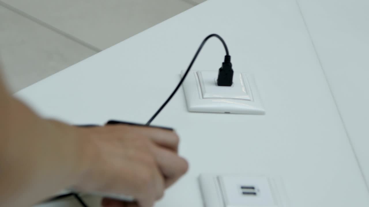 vista trasera mujer enchufa el teléfono en el puerto de carga público