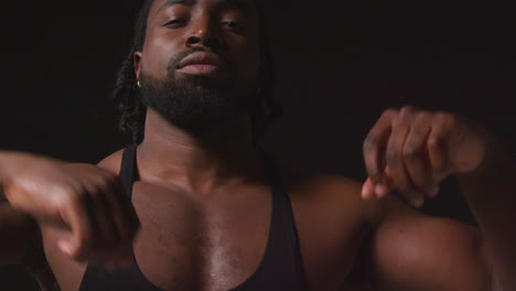 Portrait-Of-Serious-Male-Athlete-Wearing-Fitness-Vest-Training-Flexing-Muscles-And-Preparing-Psychologically-For-Sports-Event-Against-Black-Studio-Background-2