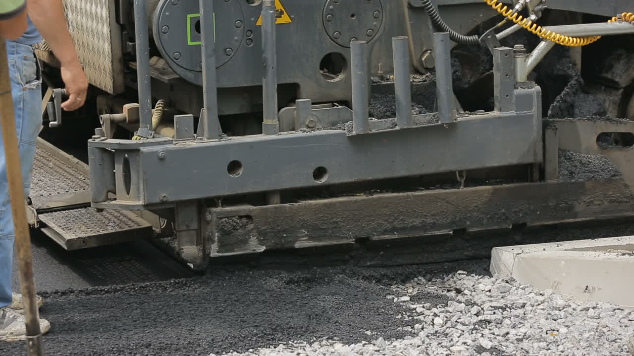 Road Roller At Road Construction Site. Pneumatic steam road rollers machines compacting fresh asphalt