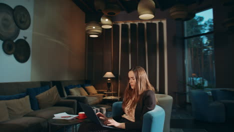 focused woman working laptop in hotel. business woman using laptop in office